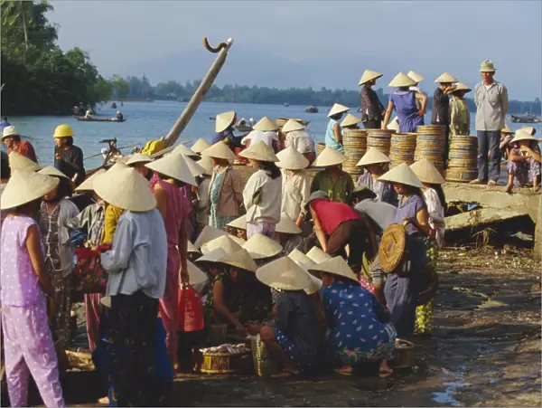 Women in conical hats at the fish market by the Thu