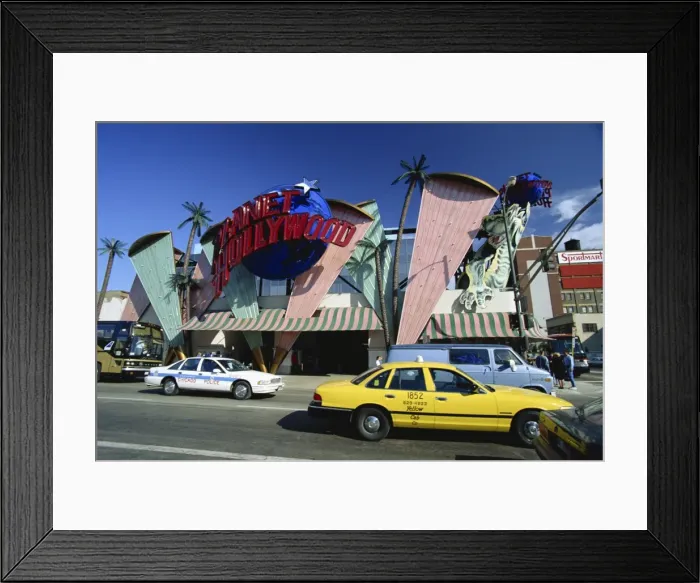 Framed Print : Planet Hollywood restaurant sign and passing taxis