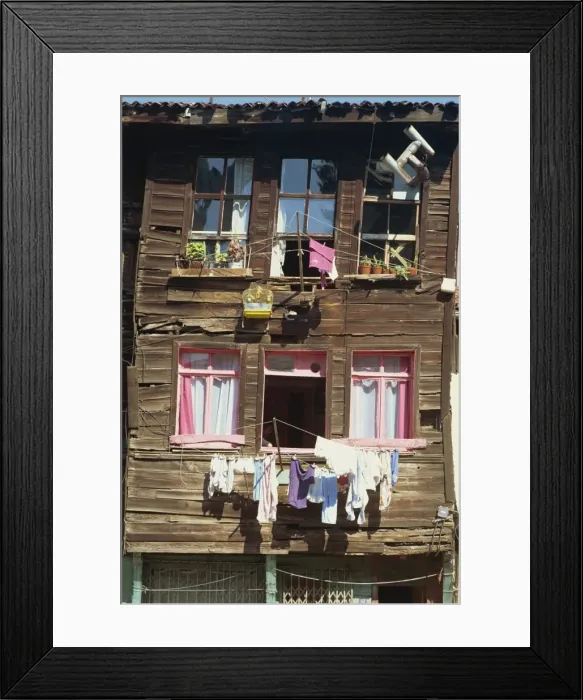 Framed Print : Bird cage and washing lines on the front of a traditional