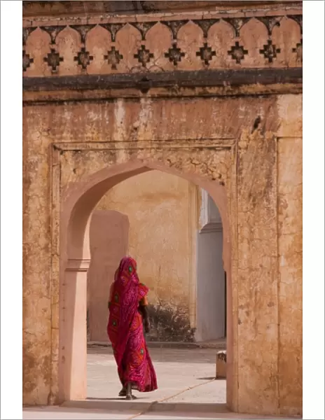 Lady in traditional dress walking through a gateway in the Amber Fort near Jaipur