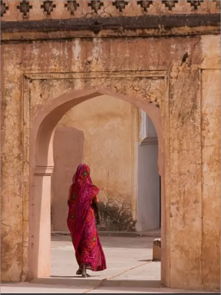 Lady in traditional dress walking through a gateway in the Amber Fort near Jaipur