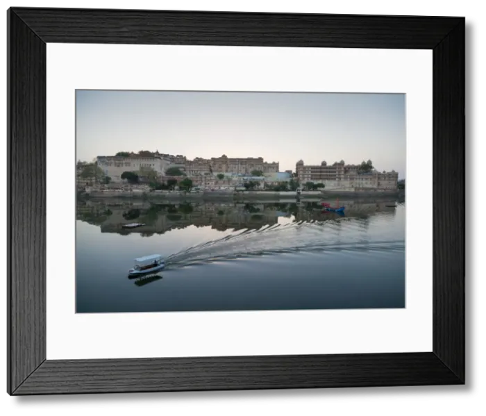 Framed Print : A water taxi passing the City Palace reflected in the still dawn waters of Lake Pichola Framed Print : A water taxi passing the City Palace reflected in the still dawn waters of Lake Pichola
