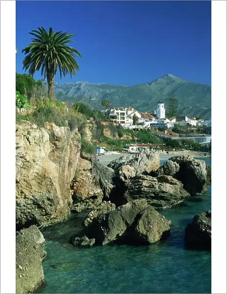 View along rocky coast to town of Nerja and mountains