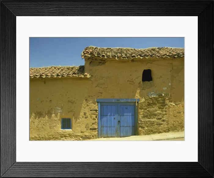 Framed Print : Exterior of an adobe house with a tile roof and blue door Framed Print : Exterior of an adobe house with a tile roof and blue door