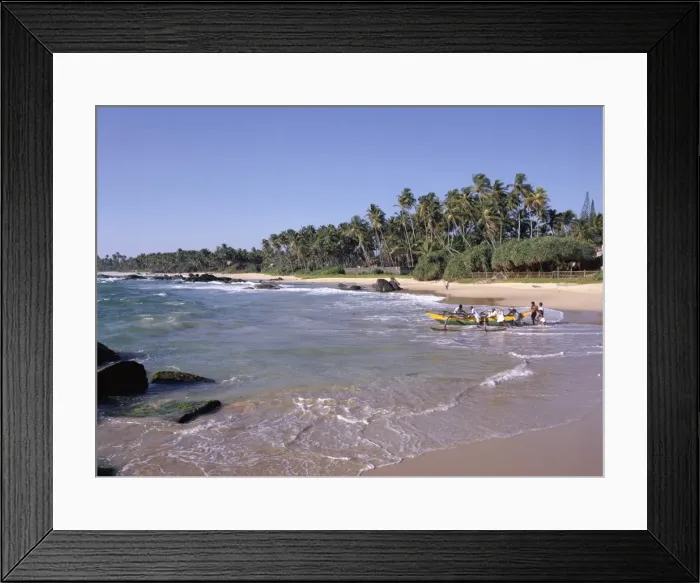 Framed Print : Men on a beach pushing boat into the sea Framed Print : Men on a beach pushing boat into the sea