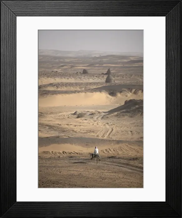 Framed Print : A man on mule-back traverses the desert around Framed Print : A man on mule-back traverses the desert around