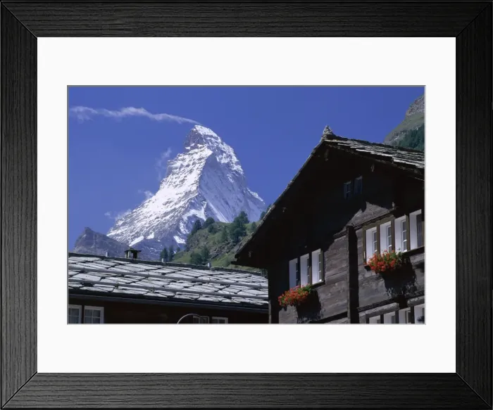 Framed Print : The peak of the Matterhorn mountain towering above chalet rooftops Framed Print : The peak of the Matterhorn mountain towering above chalet rooftops