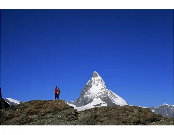 Hikers on rocks and the Matterhorn