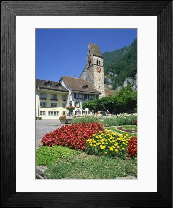 Framed Print : Summer flowers in front of houses and the clock tower Framed Print : Summer flowers in front of houses and the clock tower