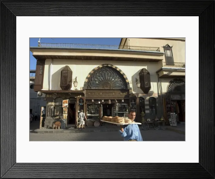 Framed Print : Man with bread walking past souvenir shop Framed Print : Man with bread walking past souvenir shop