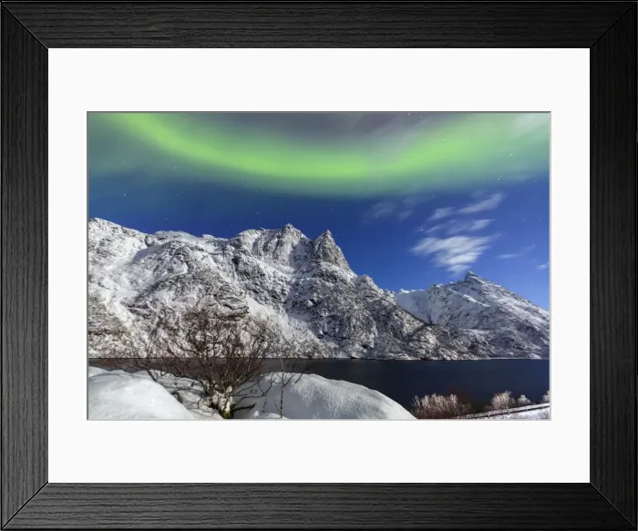Framed Print : Northern Lights (aurora borealis) illuminate the snowy peaks and the blue sky during a starry night Framed Print : Northern Lights (aurora borealis) illuminate the snowy peaks and the blue sky during a starry night