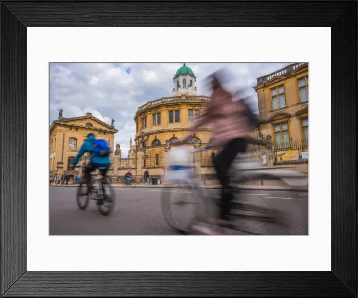 Framed Print : Cyclists passing the Sheldonian Theatre, Oxford, Oxfordshire, England, United Kingdom