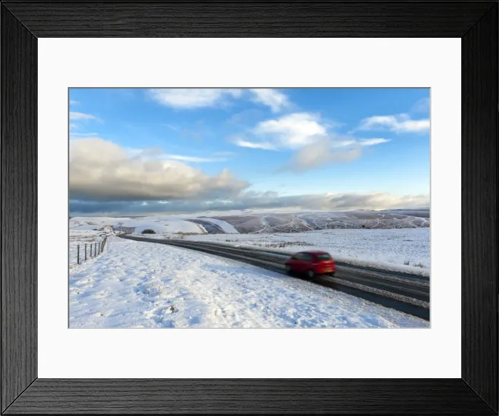Framed Print : Motorists negotiate the B4520 road between Brecon and Builth Wells on the Mynydd Epynt moorland