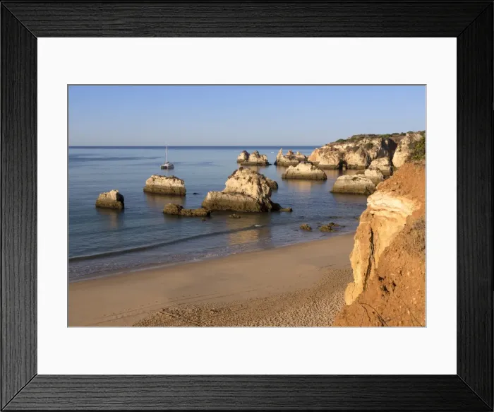 Framed Print : View of the fine sandy beach bathed by the blue ocean at dawn, Praia do Alemao, Portimao Framed Print : View of the fine sandy beach bathed by the blue ocean at dawn, Praia do Alemao, Portimao