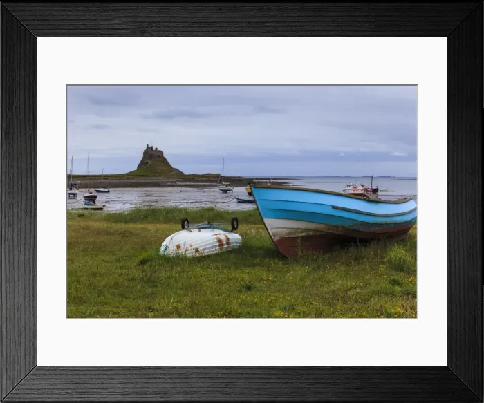 Framed Print : Fishing boats onshore and beach at low tide with Lindisfarne Castle and Farne Islands