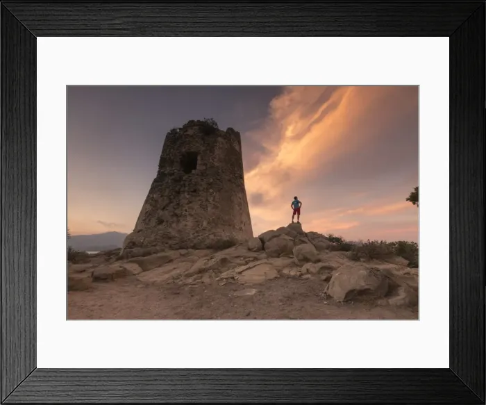 Framed Print : Hiker admires sunset from the stone tower overlooking the bay, Porto Giunco, Villasimius Framed Print : Hiker admires sunset from the stone tower overlooking the bay, Porto Giunco, Villasimius