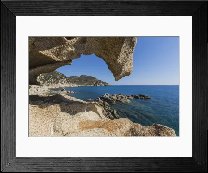 Framed Print : View of the blue sea from a natural sea cave of rocks shaped by wind, Punta Molentis