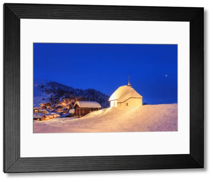 Framed Print : Blue dusk on the alpine village and church covered with snow, Bettmeralp, district of Raron Framed Print : Blue dusk on the alpine village and church covered with snow, Bettmeralp, district of Raron