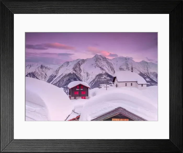 Framed Print : Pink sky at sunset frames the snowy mountain huts and church, Bettmeralp, district of Raron Framed Print : Pink sky at sunset frames the snowy mountain huts and church, Bettmeralp, district of Raron