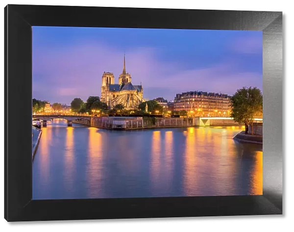 View of Notre Dame de Paris and its flying buttresses across the River Seine at blue hour
