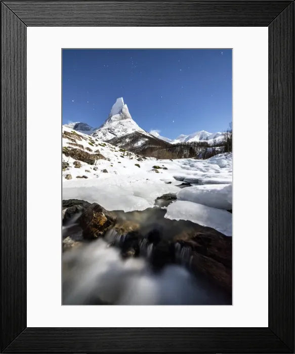 Framed Print : Ice on rocks frames the granitic snowy peak of the Stetind mountain under the starry sky