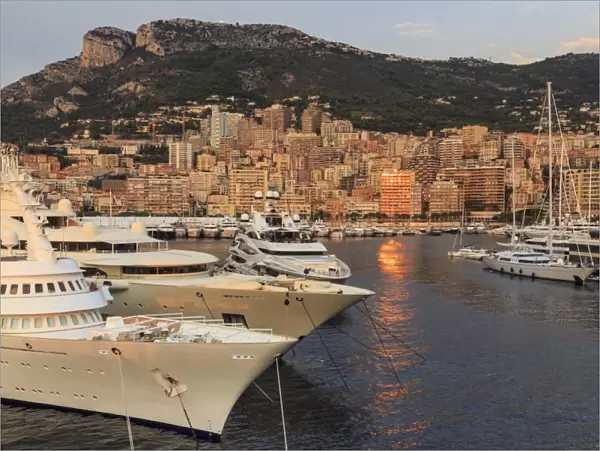 Huge super yachts in the glamorous Port of Monaco (Port Hercules) at sunrise, from the sea