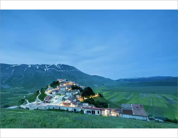 Dusk on the medieval village surrounded by green fields, Castelluccio di Norcia