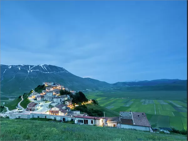 Dusk on the medieval village surrounded by green fields, Castelluccio di Norcia