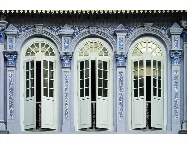 Traditional shophouse windows open out onto a street in the Orchard Road neighborhood in Singapore