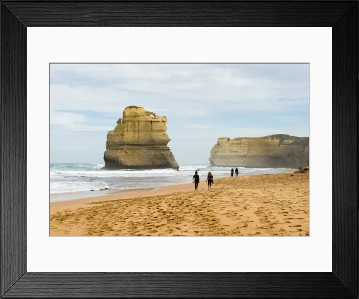 Framed Print : People walk along a beach with one of the Twelve Apostles geological formation in the background Framed Print : People walk along a beach with one of the Twelve Apostles geological formation in the background