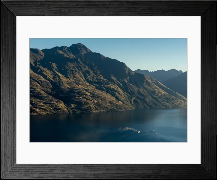 Framed Print : Steamship powers across a dark lake with sharp large mountains, Queenstown, Otago Framed Print : Steamship powers across a dark lake with sharp large mountains, Queenstown, Otago
