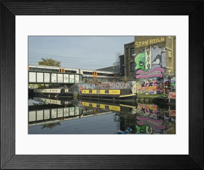 Framed Print : Overground train drives past canal by artists studios and warehouses in Hackney Wick Framed Print : Overground train drives past canal by artists studios and warehouses in Hackney Wick