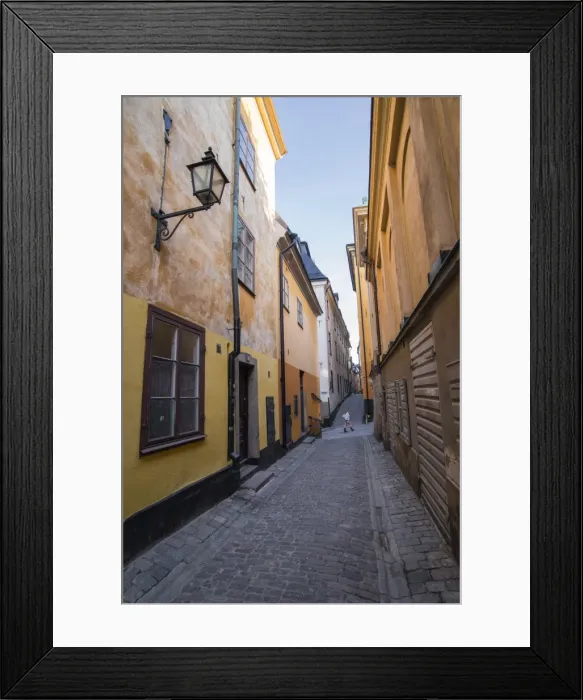 Framed Print : A pedestrian walks the streets of Stockholms colorful and historic Gamla Stan district Framed Print : A pedestrian walks the streets of Stockholms colorful and historic Gamla Stan district