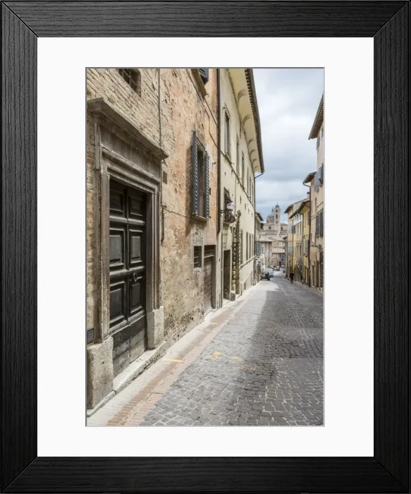 Framed Print : A medieval alley of the hill town with Piazza Duca Federico in the background, Urbino Framed Print : A medieval alley of the hill town with Piazza Duca Federico in the background, Urbino