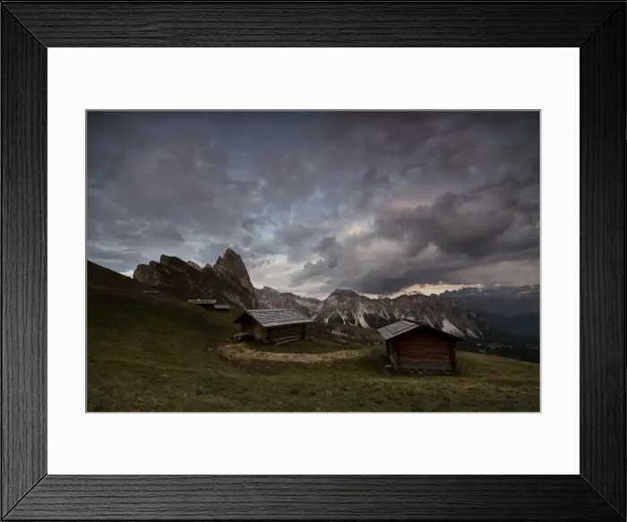 Framed Print : Dark clouds on green meadows and huts of the Odle mountain range seen from Seceda Framed Print : Dark clouds on green meadows and huts of the Odle mountain range seen from Seceda