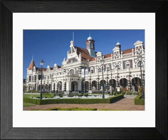 Framed Print : View from gardens to the imposing facade of Dunedin Railway Station, Anzac Square Framed Print : View from gardens to the imposing facade of Dunedin Railway Station, Anzac Square