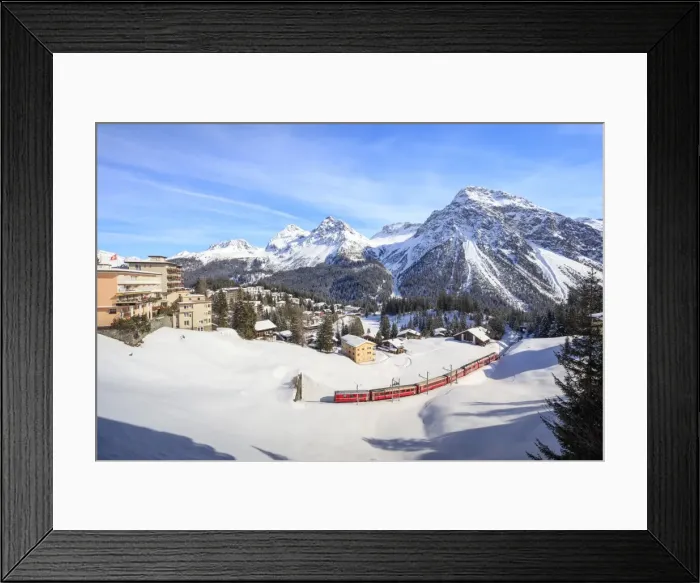 Framed Print : Red train of Rhaetian Railway passes in the snowy landscape of Arosa, district of Plessur Framed Print : Red train of Rhaetian Railway passes in the snowy landscape of Arosa, district of Plessur