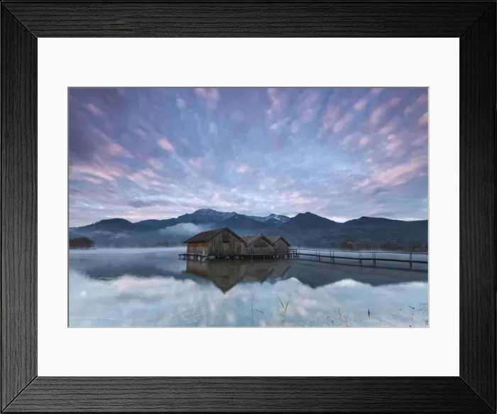 Framed Print : Pink clouds at sunset and wooden huts are reflected in the clear water of Kochelsee Framed Print : Pink clouds at sunset and wooden huts are reflected in the clear water of Kochelsee