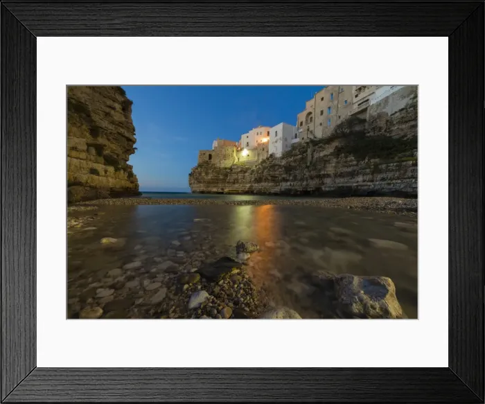 Framed Print : Dusk lights on the clear sea framed by the old town perched on the rocks, Polignano a Mare Framed Print : Dusk lights on the clear sea framed by the old town perched on the rocks, Polignano a Mare