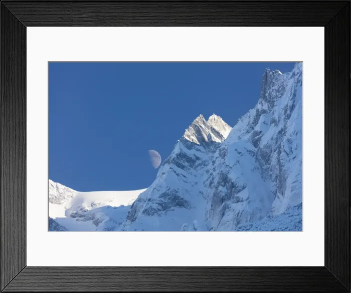 Framed Print : Blue sky and moon on the snowy ridges of the high peaks, Soglio, Bregaglia Valley