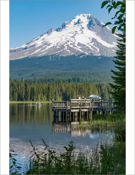 Fishing on Trillium Lake with Mount Hood, part of the Cascade Range, reflected in the still waters