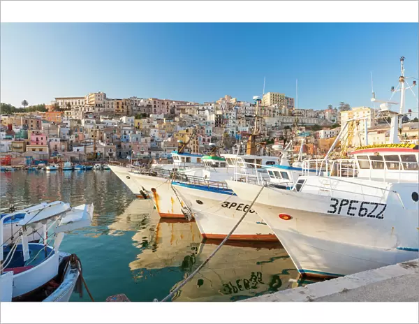 Fishing boats moored in the harbour surrounded by blue sea and the old town, Sciacca