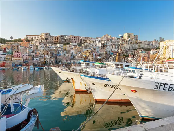Fishing boats moored in the harbour surrounded by blue sea and the old town, Sciacca