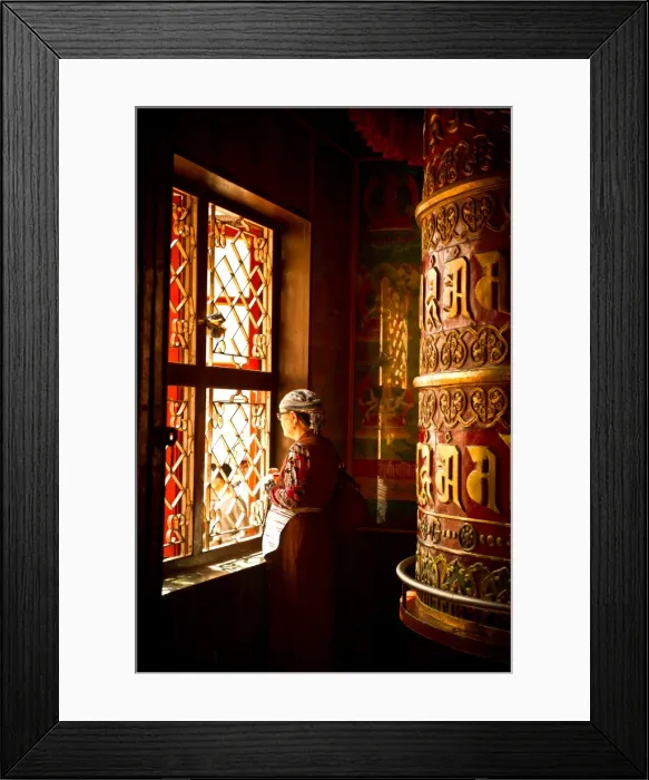 Framed Print : A Tibetan woman stands next to a large prayer wheel of the temple of Boudhanath Stupa Framed Print : A Tibetan woman stands next to a large prayer wheel of the temple of Boudhanath Stupa