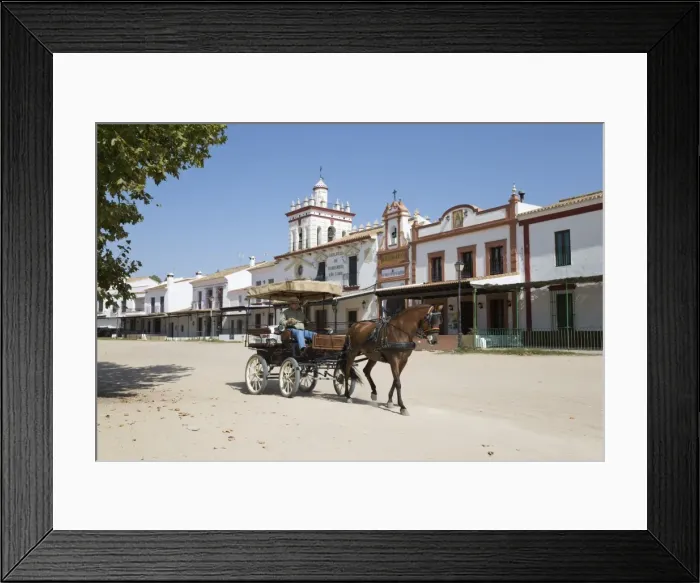 Framed Print : Horse and carriage riding along sand streets with brotherhood houses behind, El Rocio Framed Print : Horse and carriage riding along sand streets with brotherhood houses behind, El Rocio