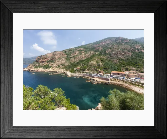 Framed Print : Top view of turquoise sea framed by green vegetation and the typical village of Porto Framed Print : Top view of turquoise sea framed by green vegetation and the typical village of Porto