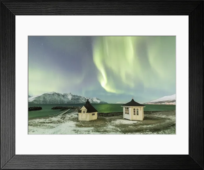 Framed Print : The Northern Lights (aurora borealis) and stars illuminate the wooden huts by icy sea Framed Print : The Northern Lights (aurora borealis) and stars illuminate the wooden huts by icy sea