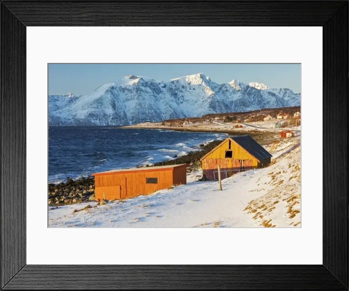 Framed Print : Typical wooden huts called Rorbu surrounded by waves of the cold sea and snowy peaks Framed Print : Typical wooden huts called Rorbu surrounded by waves of the cold sea and snowy peaks