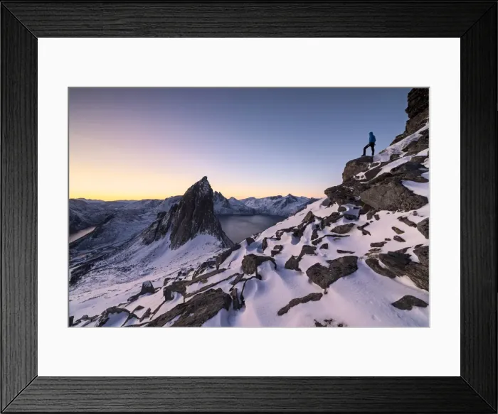 Framed Print : Hiker on peak Hesten admires Mount Segla and the Mefjorden framed by frozen sea at sunrise Framed Print : Hiker on peak Hesten admires Mount Segla and the Mefjorden framed by frozen sea at sunrise