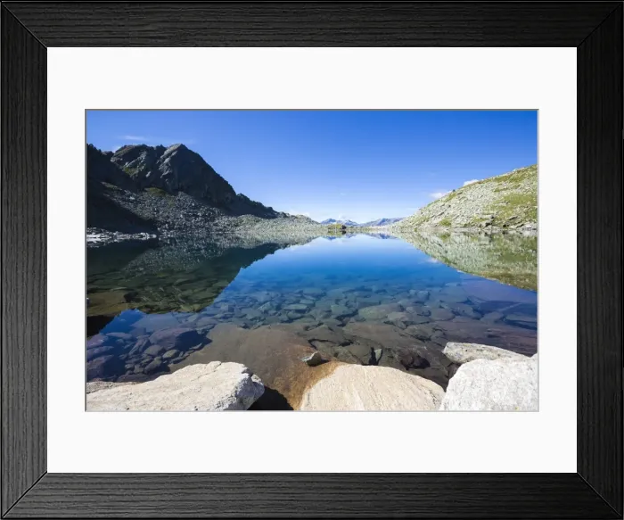 Framed Print : Blue sky and rocky peaks reflected in the blue Lago Nero, Chiavenna Valley, Valtellina Framed Print : Blue sky and rocky peaks reflected in the blue Lago Nero, Chiavenna Valley, Valtellina